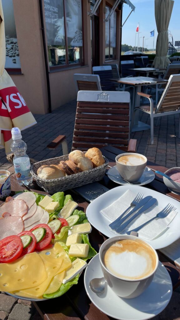 leckeres frühstück auf der Terrasse vom cafe von holiday house europa: Brötchen, aufschnitt, käse und Cappuccino 
