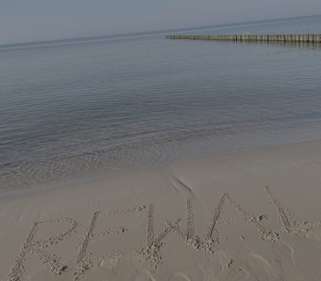 sauberes Wasser in Rewal. Auf dem Sand steht REWAL geschrieben 