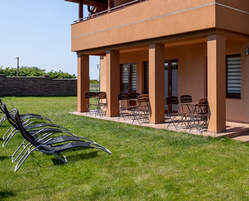 Zimmer im Erdgeschoss mit Terrasse und ohne Treppen. Vor den Zimmern stehen Sonnenliegen.